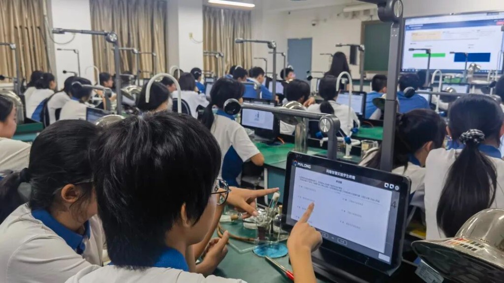 实验教室里成排学生终端与支架摄像头，前景学生正在使用码隆智慧实验学生终端